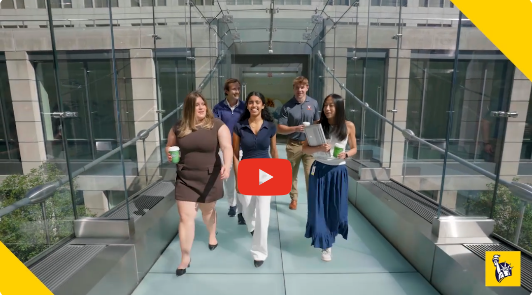 Three liberty employees walking over a glass bridge at their Boston offices